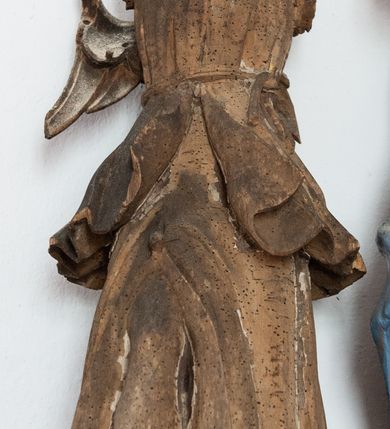 Zdjęcie nr 4: Pełnoplastyczna figura Chrystusa przybitego do krzyża trzema gwoździami. Ciało zwisa wyprężone, korpus sztywny, kolana odchylone na prawo, palce rąk częściowo przykurczone. Głowa Chrystusa opada na jego prawy bark. Ma pociągłą twarz, oczy zamknięte, usta rozchylone. Okala ją krótka, ciemnobrązowa broda i długie włosy zwinięte w pukle, opadające na plecy i barki; na głowie cienka korona cierniowa. Widoczne ślady męki, spod korony, w miejscach przebicia gwoździami i w boku zaznaczono strugi spływającej krwi. Biodra okrywa perizonium w formie białej tkaniny lamowanej złotem, przewiązanej grubym sznurem związanym na prawym biodrze. Na górnej belce krzyża, na kartuszu utworzonym z ornamentu małżowinowo-chrząskowego inskrypcja „INRI”. 