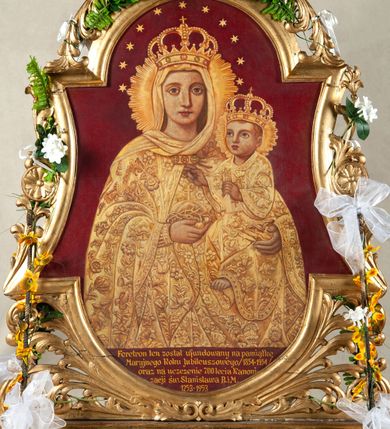 Zdjęcie nr 2: Feretron malowany, dwustronny, w kształcie zbliżonym do stojącego prostokąta zamkniętego półkoliście na prostopadłościennej podstawie. Wizerunki oprawione w złoconą, profilowaną ramę o wklęsłych bokach, od góry i od dołu zamkniętą łukiem nadwieszonym. Ramę ujmuje ażurowa wić roślinna szczególnie rozbudowania w dolnej partii. Podstawa  feretronu jest srebrzona i złocona, rama złocona. 
Na awersie wizerunek Matki Boskiej z Dzieciątkiem. Maria została ukazana w półpostaci, frontalnie, spoglądając na widza. Ma owalną twarz o delikatnych rysach, duże, niebieskie oczy, długi nos i niewielkie usta.  Lewą ręką podtrzymuje Dzieciątko, w prawej trzyma jabłko królewskie oplecione koroną cierniową. Jest ubrana w długą, złotą suknię z wąskimi rękawami i złoty płaszcz dekorowany kwiatami spięty na dekolcie fibulą z zielonymi i czerwonymi kamieniami. Dzieciątko spogląda nieco w górę, ma okrągłą twarz. Prawą ręką czyni znak błogosławieństwa, w lewej trzyma księgę. Jest ubrane w długą, złotą suknię o wzorze podobnym do umieszczonego na płaszczu Marii.  Oboje mają na głowach zamknięte korony i nimby promieniste. Głowę Marii otacza dodatkowo 11 gwiazdek. W dolnej partii obrazu napis „Feretron ten został ufundowany na pamiątkę / Maryjnego Roku Jubileuszowego /1854-1954/ / oraz na uczczenie 700 lecia Kanoni/zacji św(iętego) Stanisława B(iskupa) i M(ęczennika) / 1253-1953”. W odsłoniętych partiach ciała naturalna karnacja, tło przedstawienia jednolite, bordowe. 
Na rewersie przedstawienie św. Stanisława tronującego i wskrzeszającego Piotrowina. Biskup ma głowę przechyloną w stronę prawego barku, trójkątną twarz z dużymi oczami, wąskim nosem i małymi ustami o opadających kącikach. Prawą rękę unosi w geście błogosławieństwa, w lewej trzyma pastorał. Jest ubrany w albę, czerwoną dalmatykę lamowaną złotem, ornat, humerał  i rękawiczki; na głowie ma infułę, spod ubrań wydoczny jest lewy but. Widoczny jest fragment zielonego siedziska tronu. W dolnej części obrazu widoczny wskrzeszony Piotrowin, który składa przed sobą ręce i spogląda na świętego. Ma długie opadające puklami na plecy włosy i jest ubrany w jasną koszulę. Kolorystyka w partiach karnacji naturalna, tłu jednolicie złote. Z prawej strony, przy brzegu widoczny fragment napisu  „Obrazy malował i ofiarował / Kazimierz […]” zasłonięty częściowo ramą. 
