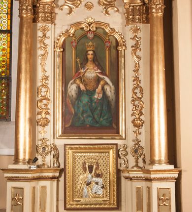 Zdjęcie nr 1: Ołtarz architektoniczny, przyścienny, jednokondygnacyjny, jednoosiowy ze zwieńczeniem. Mensa drewniana prostopadłościenna, przesłonięta prostokątnym antepedium wypełnionym tkaniną. Nastawa ustawiona na wysokim cokole ujęta pilastrami oraz stojącymi na ich tle gładkimi kolumnami kompozytowymi, podtrzymującymi odcinki rozbudowanego, częściowo ażurowego belkowania oraz fragmenty przyczółków, na których posadowiono złote aniołki o srebrnych skrzydłach. Pilastry dekorowane wicią akantową z rocaille’ami i palmetami schodzącymi do ustawionych poniżej relikwiarzy. W osi środkowej, w partii cokołu obraz Matki Boskiej Chęstochowskiej w złoto-srebrnej sukience, w prostokątnej, profilowanej, dekorowanej ramie. Powyżej obraz z wizerunkiem tronującej św. Jadwigi królowej Polski ujęty ramą w kształcie stojącego prostokąta zamkniętego od góry łukiem wklęsło-wypukłym. Powyżej dwie symetryczne plakiety ornamentalne ujmujące rozetkę. W zwieńczeniu zamkniętym łukiem nadwieszonym dekorowanym pąkami kwiatów gloria promienista z gładkim, okrągłym polem centralnym otoczonym obłokami. 
Całość struktury ołtarza polichromowana na kolor kremowy wnętrza płycin ciemniejsze, detal architektoniczny i ornamenty pozłacane i posrebrzane. 