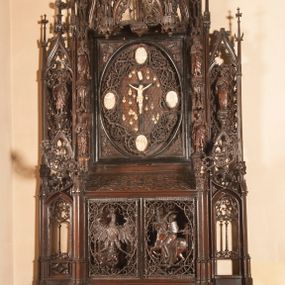 Zdjęcie nr 1: Ołtarz architektoniczny, dwukondygnacyjny ze zwieńczeniem, trójosiowy. Neogotycki na trapezowym postumencie. Mensa wsparta na dwóch  kolumnach o schodkowych, bazach w formie ośmioramiennych gwiazd na siedmiobokach z wklęsłymi ramionami. Z każdego ramienia gwiazd strzeliście unosiła się ku kapitelowi wzdłuż trzonu służka, tworząc u dołu romboidalną, wklęsłą siatkę. Struktura ta zachowała się mniej niż  w połowie na lewej kolumnie. Kapitel lewy ornamentalnie pokryty regularną siatką ze stylizowanych, suchych gałęzi, które tworzą trzy strefy pól ornamentalnych. Dolne przypominają ostre łuki, krzyżują się w nich gałęzie. Środkowe, romboidalne są puste a górne wypełniają sploty suchego akantu. Prawy kapitel posiada podobne podziały pól, różni się wypełnieniem górnej ze stref, gdzie przestrzeń całkowicie zajmują na przemian bujne winne grona oraz pochylające się kłosy zbóż. Zaplecek pod mensą, od frontu podzielono na sześć stref. Na dwóch zewnętrznych i dwóch środkowych znajdują się przedstawienia płaskorzeźbionych łuków okiennych z maswerkami. Druga płaszczyzna od lewej i prawej ozdobiona jest płaskorzeźbą roślinną. Ryzalitowana w części środkowej kondygnacja pierwsza stanowi tabernakulum na cokole. Zadaszenie spadziste pokryte różnorodnym zdobieniem, flankowane czworokątnymi filarami, na których kapitelach wspierają się ramiona ostrych łuków z wimpergami. Powyżej kapitele filarów stanowią blanki z których wyrastają ażurowe formy zbudowane z kilku esownic stylizowane na oset, zakończone profitkami. Widać wnętrze tabernakulum przez ażurowe, dwuskrzydłowe drzwiczki. Na lewych jest przestrzenna rzeźba Orła w koronie osadzona w nieznacznie uszkodzonej oprawie ze splotów gałęzi. Z prawej podobnie wykonane przedstawienie Pogoni Litewskiej. Konny rycerz ma złamany miecz. W centrum ołtarza w prostokątnej ramie znajduje się owalne pole wewnątrz otoczone ciasnym splotem guzowatych gałęzi. W środkowych punktach owalu z gałęzi wstawiono owalne  płaskorzeźby z kości słoniowej ze scenami z życia Chrystusa. W samym środku niewielka rzeźba Jezusa Ukrzyżowanego. Ramę główną flankują postacie Ewangelistów po dwóch z każdej strony, jeden nad drugim, na postumentach i pod gotyckimi baldachimami, najwyższy jest okazalszy. Zwieńczenie ołtarza stanowi wysunięta balustrada zbudowana z ostrołukowych ramion ze sterczynami, centralne ramiona zbiegają się i łączą w sterczynę zakończoną krzyżem. Ołtarz flankowany strzelistymi formami z typowych dla neogotyckiej stylizacji elementami architektonicznymi, w które wkomponowano po jednej postaci świętych z każdej strony.