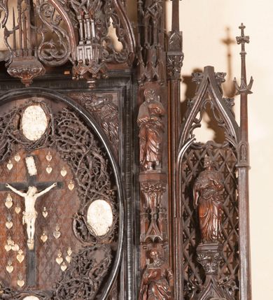 Zdjęcie nr 7: Ołtarz architektoniczny, dwukondygnacyjny ze zwieńczeniem, trójosiowy. Neogotycki na trapezowym postumencie. Mensa wsparta na dwóch  kolumnach o schodkowych, bazach w formie ośmioramiennych gwiazd na siedmiobokach z wklęsłymi ramionami. Z każdego ramienia gwiazd strzeliście unosiła się ku kapitelowi wzdłuż trzonu służka, tworząc u dołu romboidalną, wklęsłą siatkę. Struktura ta zachowała się mniej niż  w połowie na lewej kolumnie. Kapitel lewy ornamentalnie pokryty regularną siatką ze stylizowanych, suchych gałęzi, które tworzą trzy strefy pól ornamentalnych. Dolne przypominają ostre łuki, krzyżują się w nich gałęzie. Środkowe, romboidalne są puste a górne wypełniają sploty suchego akantu. Prawy kapitel posiada podobne podziały pól, różni się wypełnieniem górnej ze stref, gdzie przestrzeń całkowicie zajmują na przemian bujne winne grona oraz pochylające się kłosy zbóż. Zaplecek pod mensą, od frontu podzielono na sześć stref. Na dwóch zewnętrznych i dwóch środkowych znajdują się przedstawienia płaskorzeźbionych łuków okiennych z maswerkami. Druga płaszczyzna od lewej i prawej ozdobiona jest płaskorzeźbą roślinną. Ryzalitowana w części środkowej kondygnacja pierwsza stanowi tabernakulum na cokole. Zadaszenie spadziste pokryte różnorodnym zdobieniem, flankowane czworokątnymi filarami, na których kapitelach wspierają się ramiona ostrych łuków z wimpergami. Powyżej kapitele filarów stanowią blanki z których wyrastają ażurowe formy zbudowane z kilku esownic stylizowane na oset, zakończone profitkami. Widać wnętrze tabernakulum przez ażurowe, dwuskrzydłowe drzwiczki. Na lewych jest przestrzenna rzeźba Orła w koronie osadzona w nieznacznie uszkodzonej oprawie ze splotów gałęzi. Z prawej podobnie wykonane przedstawienie Pogoni Litewskiej. Konny rycerz ma złamany miecz. W centrum ołtarza w prostokątnej ramie znajduje się owalne pole wewnątrz otoczone ciasnym splotem guzowatych gałęzi. W środkowych punktach owalu z gałęzi wstawiono owalne  płaskorzeźby z kości słoniowej ze scenami z życia Chrystusa. W samym środku niewielka rzeźba Jezusa Ukrzyżowanego. Ramę główną flankują postacie Ewangelistów po dwóch z każdej strony, jeden nad drugim, na postumentach i pod gotyckimi baldachimami, najwyższy jest okazalszy. Zwieńczenie ołtarza stanowi wysunięta balustrada zbudowana z ostrołukowych ramion ze sterczynami, centralne ramiona zbiegają się i łączą w sterczynę zakończoną krzyżem. Ołtarz flankowany strzelistymi formami z typowych dla neogotyckiej stylizacji elementami architektonicznymi, w które wkomponowano po jednej postaci świętych z każdej strony.