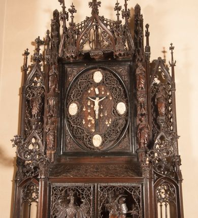 Zdjęcie nr 2: Ołtarz architektoniczny, dwukondygnacyjny ze zwieńczeniem, trójosiowy. Neogotycki na trapezowym postumencie. Mensa wsparta na dwóch  kolumnach o schodkowych, bazach w formie ośmioramiennych gwiazd na siedmiobokach z wklęsłymi ramionami. Z każdego ramienia gwiazd strzeliście unosiła się ku kapitelowi wzdłuż trzonu służka, tworząc u dołu romboidalną, wklęsłą siatkę. Struktura ta zachowała się mniej niż  w połowie na lewej kolumnie. Kapitel lewy ornamentalnie pokryty regularną siatką ze stylizowanych, suchych gałęzi, które tworzą trzy strefy pól ornamentalnych. Dolne przypominają ostre łuki, krzyżują się w nich gałęzie. Środkowe, romboidalne są puste a górne wypełniają sploty suchego akantu. Prawy kapitel posiada podobne podziały pól, różni się wypełnieniem górnej ze stref, gdzie przestrzeń całkowicie zajmują na przemian bujne winne grona oraz pochylające się kłosy zbóż. Zaplecek pod mensą, od frontu podzielono na sześć stref. Na dwóch zewnętrznych i dwóch środkowych znajdują się przedstawienia płaskorzeźbionych łuków okiennych z maswerkami. Druga płaszczyzna od lewej i prawej ozdobiona jest płaskorzeźbą roślinną. Ryzalitowana w części środkowej kondygnacja pierwsza stanowi tabernakulum na cokole. Zadaszenie spadziste pokryte różnorodnym zdobieniem, flankowane czworokątnymi filarami, na których kapitelach wspierają się ramiona ostrych łuków z wimpergami. Powyżej kapitele filarów stanowią blanki z których wyrastają ażurowe formy zbudowane z kilku esownic stylizowane na oset, zakończone profitkami. Widać wnętrze tabernakulum przez ażurowe, dwuskrzydłowe drzwiczki. Na lewych jest przestrzenna rzeźba Orła w koronie osadzona w nieznacznie uszkodzonej oprawie ze splotów gałęzi. Z prawej podobnie wykonane przedstawienie Pogoni Litewskiej. Konny rycerz ma złamany miecz. W centrum ołtarza w prostokątnej ramie znajduje się owalne pole wewnątrz otoczone ciasnym splotem guzowatych gałęzi. W środkowych punktach owalu z gałęzi wstawiono owalne  płaskorzeźby z kości słoniowej ze scenami z życia Chrystusa. W samym środku niewielka rzeźba Jezusa Ukrzyżowanego. Ramę główną flankują postacie Ewangelistów po dwóch z każdej strony, jeden nad drugim, na postumentach i pod gotyckimi baldachimami, najwyższy jest okazalszy. Zwieńczenie ołtarza stanowi wysunięta balustrada zbudowana z ostrołukowych ramion ze sterczynami, centralne ramiona zbiegają się i łączą w sterczynę zakończoną krzyżem. Ołtarz flankowany strzelistymi formami z typowych dla neogotyckiej stylizacji elementami architektonicznymi, w które wkomponowano po jednej postaci świętych z każdej strony.