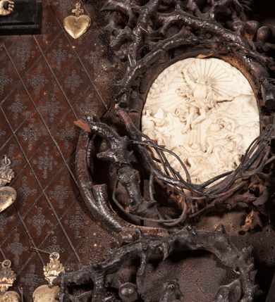 Zdjęcie nr 22: Ołtarz architektoniczny, dwukondygnacyjny ze zwieńczeniem, trójosiowy. Neogotycki na trapezowym postumencie. Mensa wsparta na dwóch  kolumnach o schodkowych, bazach w formie ośmioramiennych gwiazd na siedmiobokach z wklęsłymi ramionami. Z każdego ramienia gwiazd strzeliście unosiła się ku kapitelowi wzdłuż trzonu służka, tworząc u dołu romboidalną, wklęsłą siatkę. Struktura ta zachowała się mniej niż  w połowie na lewej kolumnie. Kapitel lewy ornamentalnie pokryty regularną siatką ze stylizowanych, suchych gałęzi, które tworzą trzy strefy pól ornamentalnych. Dolne przypominają ostre łuki, krzyżują się w nich gałęzie. Środkowe, romboidalne są puste a górne wypełniają sploty suchego akantu. Prawy kapitel posiada podobne podziały pól, różni się wypełnieniem górnej ze stref, gdzie przestrzeń całkowicie zajmują na przemian bujne winne grona oraz pochylające się kłosy zbóż. Zaplecek pod mensą, od frontu podzielono na sześć stref. Na dwóch zewnętrznych i dwóch środkowych znajdują się przedstawienia płaskorzeźbionych łuków okiennych z maswerkami. Druga płaszczyzna od lewej i prawej ozdobiona jest płaskorzeźbą roślinną. Ryzalitowana w części środkowej kondygnacja pierwsza stanowi tabernakulum na cokole. Zadaszenie spadziste pokryte różnorodnym zdobieniem, flankowane czworokątnymi filarami, na których kapitelach wspierają się ramiona ostrych łuków z wimpergami. Powyżej kapitele filarów stanowią blanki z których wyrastają ażurowe formy zbudowane z kilku esownic stylizowane na oset, zakończone profitkami. Widać wnętrze tabernakulum przez ażurowe, dwuskrzydłowe drzwiczki. Na lewych jest przestrzenna rzeźba Orła w koronie osadzona w nieznacznie uszkodzonej oprawie ze splotów gałęzi. Z prawej podobnie wykonane przedstawienie Pogoni Litewskiej. Konny rycerz ma złamany miecz. W centrum ołtarza w prostokątnej ramie znajduje się owalne pole wewnątrz otoczone ciasnym splotem guzowatych gałęzi. W środkowych punktach owalu z gałęzi wstawiono owalne  płaskorzeźby z kości słoniowej ze scenami z życia Chrystusa. W samym środku niewielka rzeźba Jezusa Ukrzyżowanego. Ramę główną flankują postacie Ewangelistów po dwóch z każdej strony, jeden nad drugim, na postumentach i pod gotyckimi baldachimami, najwyższy jest okazalszy. Zwieńczenie ołtarza stanowi wysunięta balustrada zbudowana z ostrołukowych ramion ze sterczynami, centralne ramiona zbiegają się i łączą w sterczynę zakończoną krzyżem. Ołtarz flankowany strzelistymi formami z typowych dla neogotyckiej stylizacji elementami architektonicznymi, w które wkomponowano po jednej postaci świętych z każdej strony.