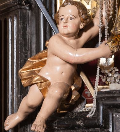 Zdjęcie nr 24: Ołtarz prostopadłościenny, w typie tumbowym, z mensą o brzegu zdobionym rzędem liści akantu naprzemian z łukami kotarowymi zwieńczonymi kulami oraz podwieszonym lambrekinem. Nastawa ołtarzowa jest architektoniczna, jednoosiowa ze zwieńczeniem, ujęta przez kolumny stojące na ukośnie dostawionych cokołach. Kolumny w jednej trzeciej kanelowane w dwóch trzecich skręcone z wplecioną złoconą wicią roślinną, ze złoconym kapitelem podtrzymują przerwany przyczółek ze ślimacznicami, na którym siedzą aniołki. Belkowanie bogato profilowane nad częścią środkową jest wyłamane trzema wklęsłymi łukami. Zwieńczenie jest utworzone z owalnego obrazu z przedstawieniem św. Kingi, w profilowanej ramie ujętej wieńcem z lauru.   

