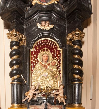 Zdjęcie nr 2: Ołtarz prostopadłościenny, w typie tumbowym, z mensą o brzegu zdobionym rzędem liści akantu naprzemian z łukami kotarowymi zwieńczonymi kulami oraz podwieszonym lambrekinem. Nastawa ołtarzowa jest architektoniczna, jednoosiowa ze zwieńczeniem, ujęta przez kolumny stojące na ukośnie dostawionych cokołach. Kolumny w jednej trzeciej kanelowane w dwóch trzecich skręcone z wplecioną złoconą wicią roślinną, ze złoconym kapitelem podtrzymują przerwany przyczółek ze ślimacznicami, na którym siedzą aniołki. Belkowanie bogato profilowane nad częścią środkową jest wyłamane trzema wklęsłymi łukami. Zwieńczenie jest utworzone z owalnego obrazu z przedstawieniem św. Kingi, w profilowanej ramie ujętej wieńcem z lauru.   

