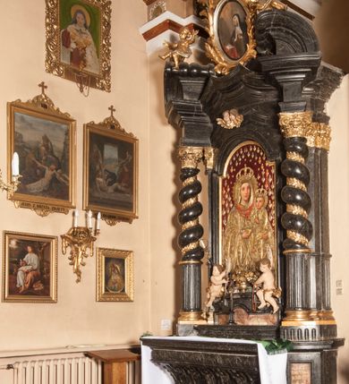 Zdjęcie nr 7: Ołtarz prostopadłościenny, w typie tumbowym, z mensą o brzegu zdobionym rzędem liści akantu naprzemian z łukami kotarowymi zwieńczonymi kulami oraz podwieszonym lambrekinem. Nastawa ołtarzowa jest architektoniczna, jednoosiowa ze zwieńczeniem, ujęta przez kolumny stojące na ukośnie dostawionych cokołach. Kolumny w jednej trzeciej kanelowane w dwóch trzecich skręcone z wplecioną złoconą wicią roślinną, ze złoconym kapitelem podtrzymują przerwany przyczółek ze ślimacznicami, na którym siedzą aniołki. Belkowanie bogato profilowane nad częścią środkową jest wyłamane trzema wklęsłymi łukami. Zwieńczenie jest utworzone z owalnego obrazu z przedstawieniem św. Kingi, w profilowanej ramie ujętej wieńcem z lauru.   

