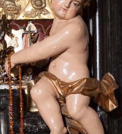 Zdjęcie nr 19: Ołtarz prostopadłościenny, w typie tumbowym, z mensą o brzegu zdobionym rzędem liści akantu naprzemian z łukami kotarowymi zwieńczonymi kulami oraz podwieszonym lambrekinem. Nastawa ołtarzowa jest architektoniczna, jednoosiowa ze zwieńczeniem, ujęta przez kolumny stojące na ukośnie dostawionych cokołach. Kolumny w jednej trzeciej kanelowane w dwóch trzecich skręcone z wplecioną złoconą wicią roślinną, ze złoconym kapitelem podtrzymują przerwany przyczółek ze ślimacznicami, na którym siedzą aniołki. Belkowanie bogato profilowane nad częścią środkową jest wyłamane trzema wklęsłymi łukami. Zwieńczenie jest utworzone z owalnego obrazu z przedstawieniem św. Kingi, w profilowanej ramie ujętej wieńcem z lauru.   

