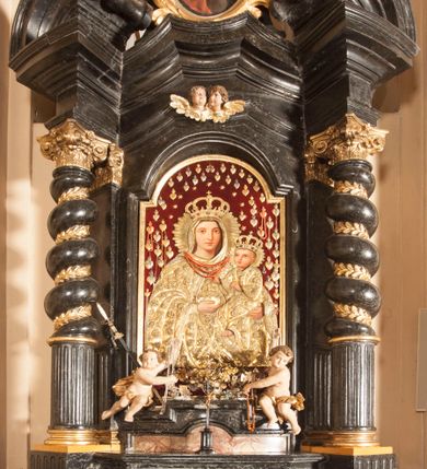 Zdjęcie nr 4: Ołtarz prostopadłościenny, w typie tumbowym, z mensą o brzegu zdobionym rzędem liści akantu naprzemian z łukami kotarowymi zwieńczonymi kulami oraz podwieszonym lambrekinem. Nastawa ołtarzowa jest architektoniczna, jednoosiowa ze zwieńczeniem, ujęta przez kolumny stojące na ukośnie dostawionych cokołach. Kolumny w jednej trzeciej kanelowane w dwóch trzecich skręcone z wplecioną złoconą wicią roślinną, ze złoconym kapitelem podtrzymują przerwany przyczółek ze ślimacznicami, na którym siedzą aniołki. Belkowanie bogato profilowane nad częścią środkową jest wyłamane trzema wklęsłymi łukami. Zwieńczenie jest utworzone z owalnego obrazu z przedstawieniem św. Kingi, w profilowanej ramie ujętej wieńcem z lauru.   

