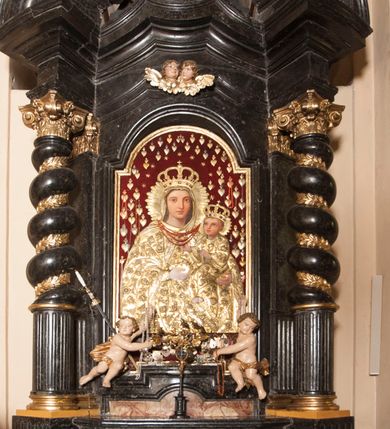 Zdjęcie nr 3: Ołtarz prostopadłościenny, w typie tumbowym, z mensą o brzegu zdobionym rzędem liści akantu naprzemian z łukami kotarowymi zwieńczonymi kulami oraz podwieszonym lambrekinem. Nastawa ołtarzowa jest architektoniczna, jednoosiowa ze zwieńczeniem, ujęta przez kolumny stojące na ukośnie dostawionych cokołach. Kolumny w jednej trzeciej kanelowane w dwóch trzecich skręcone z wplecioną złoconą wicią roślinną, ze złoconym kapitelem podtrzymują przerwany przyczółek ze ślimacznicami, na którym siedzą aniołki. Belkowanie bogato profilowane nad częścią środkową jest wyłamane trzema wklęsłymi łukami. Zwieńczenie jest utworzone z owalnego obrazu z przedstawieniem św. Kingi, w profilowanej ramie ujętej wieńcem z lauru.   

