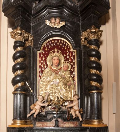 Zdjęcie nr 5: Ołtarz prostopadłościenny, w typie tumbowym, z mensą o brzegu zdobionym rzędem liści akantu naprzemian z łukami kotarowymi zwieńczonymi kulami oraz podwieszonym lambrekinem. Nastawa ołtarzowa jest architektoniczna, jednoosiowa ze zwieńczeniem, ujęta przez kolumny stojące na ukośnie dostawionych cokołach. Kolumny w jednej trzeciej kanelowane w dwóch trzecich skręcone z wplecioną złoconą wicią roślinną, ze złoconym kapitelem podtrzymują przerwany przyczółek ze ślimacznicami, na którym siedzą aniołki. Belkowanie bogato profilowane nad częścią środkową jest wyłamane trzema wklęsłymi łukami. Zwieńczenie jest utworzone z owalnego obrazu z przedstawieniem św. Kingi, w profilowanej ramie ujętej wieńcem z lauru.   

