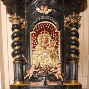 Zdjęcie nr 1: Ołtarz prostopadłościenny, w typie tumbowym, z mensą o brzegu zdobionym rzędem liści akantu naprzemian z łukami kotarowymi zwieńczonymi kulami oraz podwieszonym lambrekinem. Nastawa ołtarzowa jest architektoniczna, jednoosiowa ze zwieńczeniem, ujęta przez kolumny stojące na ukośnie dostawionych cokołach. Kolumny w jednej trzeciej kanelowane w dwóch trzecich skręcone z wplecioną złoconą wicią roślinną, ze złoconym kapitelem podtrzymują przerwany przyczółek ze ślimacznicami, na którym siedzą aniołki. Belkowanie bogato profilowane nad częścią środkową jest wyłamane trzema wklęsłymi łukami. Zwieńczenie jest utworzone z owalnego obrazu z przedstawieniem św. Kingi, w profilowanej ramie ujętej wieńcem z lauru.   

