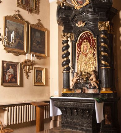 Zdjęcie nr 6: Ołtarz prostopadłościenny, w typie tumbowym, z mensą o brzegu zdobionym rzędem liści akantu naprzemian z łukami kotarowymi zwieńczonymi kulami oraz podwieszonym lambrekinem. Nastawa ołtarzowa jest architektoniczna, jednoosiowa ze zwieńczeniem, ujęta przez kolumny stojące na ukośnie dostawionych cokołach. Kolumny w jednej trzeciej kanelowane w dwóch trzecich skręcone z wplecioną złoconą wicią roślinną, ze złoconym kapitelem podtrzymują przerwany przyczółek ze ślimacznicami, na którym siedzą aniołki. Belkowanie bogato profilowane nad częścią środkową jest wyłamane trzema wklęsłymi łukami. Zwieńczenie jest utworzone z owalnego obrazu z przedstawieniem św. Kingi, w profilowanej ramie ujętej wieńcem z lauru.   

