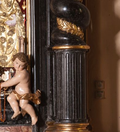 Zdjęcie nr 14: Ołtarz prostopadłościenny, w typie tumbowym, z mensą o brzegu zdobionym rzędem liści akantu naprzemian z łukami kotarowymi zwieńczonymi kulami oraz podwieszonym lambrekinem. Nastawa ołtarzowa jest architektoniczna, jednoosiowa ze zwieńczeniem, ujęta przez kolumny stojące na ukośnie dostawionych cokołach. Kolumny w jednej trzeciej kanelowane w dwóch trzecich skręcone z wplecioną złoconą wicią roślinną, ze złoconym kapitelem podtrzymują przerwany przyczółek ze ślimacznicami, na którym siedzą aniołki. Belkowanie bogato profilowane nad częścią środkową jest wyłamane trzema wklęsłymi łukami. Zwieńczenie jest utworzone z owalnego obrazu z przedstawieniem św. Kingi, w profilowanej ramie ujętej wieńcem z lauru.   

