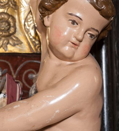 Zdjęcie nr 20: Ołtarz prostopadłościenny, w typie tumbowym, z mensą o brzegu zdobionym rzędem liści akantu naprzemian z łukami kotarowymi zwieńczonymi kulami oraz podwieszonym lambrekinem. Nastawa ołtarzowa jest architektoniczna, jednoosiowa ze zwieńczeniem, ujęta przez kolumny stojące na ukośnie dostawionych cokołach. Kolumny w jednej trzeciej kanelowane w dwóch trzecich skręcone z wplecioną złoconą wicią roślinną, ze złoconym kapitelem podtrzymują przerwany przyczółek ze ślimacznicami, na którym siedzą aniołki. Belkowanie bogato profilowane nad częścią środkową jest wyłamane trzema wklęsłymi łukami. Zwieńczenie jest utworzone z owalnego obrazu z przedstawieniem św. Kingi, w profilowanej ramie ujętej wieńcem z lauru.   

