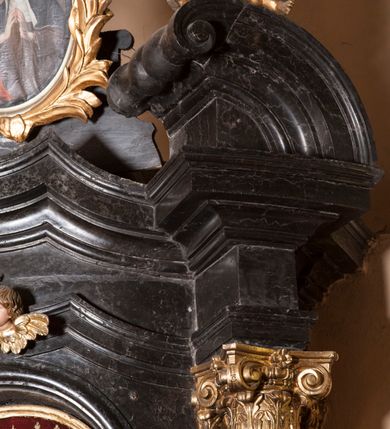 Zdjęcie nr 17: Ołtarz prostopadłościenny, w typie tumbowym, z mensą o brzegu zdobionym rzędem liści akantu naprzemian z łukami kotarowymi zwieńczonymi kulami oraz podwieszonym lambrekinem. Nastawa ołtarzowa jest architektoniczna, jednoosiowa ze zwieńczeniem, ujęta przez kolumny stojące na ukośnie dostawionych cokołach. Kolumny w jednej trzeciej kanelowane w dwóch trzecich skręcone z wplecioną złoconą wicią roślinną, ze złoconym kapitelem podtrzymują przerwany przyczółek ze ślimacznicami, na którym siedzą aniołki. Belkowanie bogato profilowane nad częścią środkową jest wyłamane trzema wklęsłymi łukami. Zwieńczenie jest utworzone z owalnego obrazu z przedstawieniem św. Kingi, w profilowanej ramie ujętej wieńcem z lauru.   

