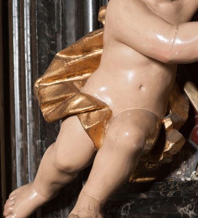 Zdjęcie nr 25: Ołtarz prostopadłościenny, w typie tumbowym, z mensą o brzegu zdobionym rzędem liści akantu naprzemian z łukami kotarowymi zwieńczonymi kulami oraz podwieszonym lambrekinem. Nastawa ołtarzowa jest architektoniczna, jednoosiowa ze zwieńczeniem, ujęta przez kolumny stojące na ukośnie dostawionych cokołach. Kolumny w jednej trzeciej kanelowane w dwóch trzecich skręcone z wplecioną złoconą wicią roślinną, ze złoconym kapitelem podtrzymują przerwany przyczółek ze ślimacznicami, na którym siedzą aniołki. Belkowanie bogato profilowane nad częścią środkową jest wyłamane trzema wklęsłymi łukami. Zwieńczenie jest utworzone z owalnego obrazu z przedstawieniem św. Kingi, w profilowanej ramie ujętej wieńcem z lauru.   

