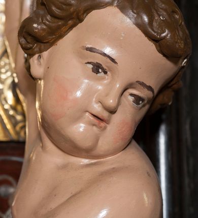 Zdjęcie nr 21: Ołtarz prostopadłościenny, w typie tumbowym, z mensą o brzegu zdobionym rzędem liści akantu naprzemian z łukami kotarowymi zwieńczonymi kulami oraz podwieszonym lambrekinem. Nastawa ołtarzowa jest architektoniczna, jednoosiowa ze zwieńczeniem, ujęta przez kolumny stojące na ukośnie dostawionych cokołach. Kolumny w jednej trzeciej kanelowane w dwóch trzecich skręcone z wplecioną złoconą wicią roślinną, ze złoconym kapitelem podtrzymują przerwany przyczółek ze ślimacznicami, na którym siedzą aniołki. Belkowanie bogato profilowane nad częścią środkową jest wyłamane trzema wklęsłymi łukami. Zwieńczenie jest utworzone z owalnego obrazu z przedstawieniem św. Kingi, w profilowanej ramie ujętej wieńcem z lauru.   

