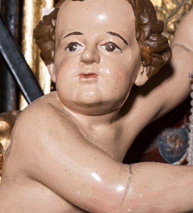 Zdjęcie nr 26: Ołtarz prostopadłościenny, w typie tumbowym, z mensą o brzegu zdobionym rzędem liści akantu naprzemian z łukami kotarowymi zwieńczonymi kulami oraz podwieszonym lambrekinem. Nastawa ołtarzowa jest architektoniczna, jednoosiowa ze zwieńczeniem, ujęta przez kolumny stojące na ukośnie dostawionych cokołach. Kolumny w jednej trzeciej kanelowane w dwóch trzecich skręcone z wplecioną złoconą wicią roślinną, ze złoconym kapitelem podtrzymują przerwany przyczółek ze ślimacznicami, na którym siedzą aniołki. Belkowanie bogato profilowane nad częścią środkową jest wyłamane trzema wklęsłymi łukami. Zwieńczenie jest utworzone z owalnego obrazu z przedstawieniem św. Kingi, w profilowanej ramie ujętej wieńcem z lauru.   

