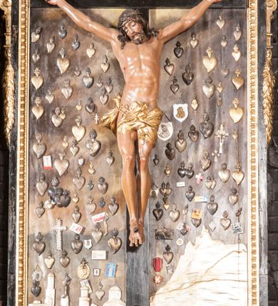 Zdjęcie nr 4: Ołtarz architektoniczny, jednoosiowy, jednokondygnacyjny ze zwieńczeniem. Jego mensa jest w typie tumbowym, antepedium w kształcie płyciny wypełnionej różowym marmurem paczółtowickim, z półkolistymi wcięciami na dłuższych bokach. Nastawa jest ujęta zwielokrotnionymi pilastrami o kompozytowych kapitelach, złoconych, podtrzymujących odcinki belkowania z ćwierćkolistymi naczółkami. Belkowanie połączone w partii architrawu, wygiętego łukowato. Zwieńczenie ujęte spływami wolutowymi, podtrzymującymi gzyms o formie łuku nadwieszonego. W polu środkowym rzeźba Chrystusa na krzyżu, na tle płaskorzeźbionego widoku Jerozolimy, ujętego drewnianą, złoconą ramą w formie stojącego prostokąta, z wyciętą łukowato dolną krawędzią i ściętymi ćwierćkoliście narożami, zwieńczonego podwójnym łukiem półkolistym, nadwieszonym. Na całej powierzchni widoku Jerozolimy ulokowane liczne wota. W zwieńczeniu obraz ze sceną Wskrzeszenia Piotrowina, w fantazyjnie wyciętej ramie o bokach krótszych wybrzuszonych a długich wklęsłych. 

