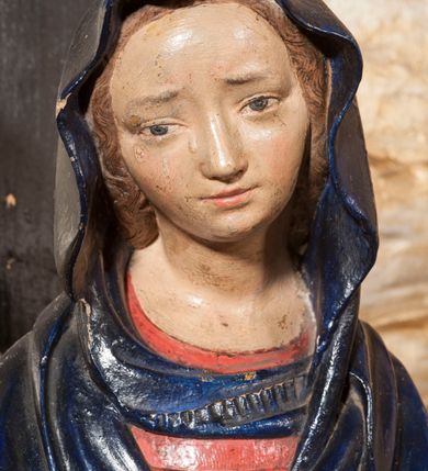 Zdjęcie nr 5: Rzeźba przedstawia siedzącą Marię trzymającą na kolanach ciało swego syna. Maria ustawiona frontalnie, z torsem skręconym lekko w prawo, ubrana w czerwoną suknię i ciemnoniebieski płaszcz z kapturem na głowie. Prawą ręką podtrzymuje syna, a lewą ujmuje go za prawą rękę. Twarz okrągła, pochylona ku Jezusowi, widać na niej boleść; oczy i włosy ciemne, długi nos i zwięzłe usta. Ciało Chrystusa odziane tylko w perizonium spoczywa na kolanach matki, tułów i głowa proste, nogi w kolanach opadają na ziemię, korpus wychudzony tak, że widać żebra i ślady po gwoździach. Głowa w nienaturalnej pozie, prawie w jednej linii z tułowiem, na twarzy widać ból; oczy zamknięte, usta lekko otwarte. Długie do ramion włosy otaczają głowę, lekko zaznaczona broda.