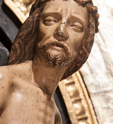 Zdjęcie nr 9: Rzeźba przedstawia siedzącą Marię trzymającą na kolanach ciało swego syna. Maria ustawiona frontalnie, z torsem skręconym lekko w prawo, ubrana w czerwoną suknię i ciemnoniebieski płaszcz z kapturem na głowie. Prawą ręką podtrzymuje syna, a lewą ujmuje go za prawą rękę. Twarz okrągła, pochylona ku Jezusowi, widać na niej boleść; oczy i włosy ciemne, długi nos i zwięzłe usta. Ciało Chrystusa odziane tylko w perizonium spoczywa na kolanach matki, tułów i głowa proste, nogi w kolanach opadają na ziemię, korpus wychudzony tak, że widać żebra i ślady po gwoździach. Głowa w nienaturalnej pozie, prawie w jednej linii z tułowiem, na twarzy widać ból; oczy zamknięte, usta lekko otwarte. Długie do ramion włosy otaczają głowę, lekko zaznaczona broda.