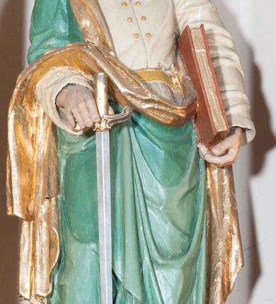 Zdjęcie nr 14: Ołtarz architektoniczny,  przyścienny, trójosiowy, jednokondygnacyjny ze zwieńczeniem. Mensa ołtarzowa kamienna, sarkofagowa, przesłonięta drewnianym antepedium, w centrum którego umieszczono pastorał, krzyż, infułę i księgę w otoczeniu winnej latorośli. Antepedium otoczone ramą ze zdobionymi narożami. Na mensie ustawiono tabernakulum dwukondygnacyjne ze zwieńczeniem, flankowane kolumnami kompozytowymi z pierścieniami w połowie. W dolnej kondygnacji metalowy front z drzwiami o wykroju łuku, zdobionymi splotem kłosów zbóż i kiści winogron. W górnej kondygnacji srebrna płaskorzeźba pelikana karmiącego trzy pisklęta. Po bokach siedzą dwa aniołki. Tabernakulum flankowane stylizowanym przestrzennym ornamentem akantowym. Nastawa posadowiona na wysokim, dekorowanym płycinami, dwudzielnym cokole, którego boczne osie zostały ustawione skośnie w stosunku do głównej. W polu centralnym obraz ze sceną wskrzeszenie Piotrowina przez św. Stanisława w kształcie prostokąta zamkniętego od góry łukiem półkolistym, w złoconej, profilowanej ramie otoczonej srebrnymi orłami oraz stylizowaną wicią roślinną. Powyżej, w zwieńczeniu gloria promienista. W jej centrum Trójca Święta: tronujący wśród obłoków i aniołków Chrystus po lewej stronie i Bóg Ojciec po prawej; powyżej nich unosi się gołębica Ducha Świętego. Otaczająca scenę gloria promienista została skomponowana z wiązek krótszych i dłuższych promieni naprzemiennie srebrnych i złotych, rzadziej rozlokowanych w dolnej części. Boczne osie składają się z ustawionych uskokowo na tle pilastrów par kolumn kompozytowych podtrzymujących rozbudowane, wyłamane na ich osiach belkowanie. Cokoły kolumn są dekorowane płycinami wypełnionymi ornamentem, a między nimi  na konsolach ustawiono figury świętych: Piotra po prawej stronie i Pawła po lewej. Na zewnętrznych częściach belkowania umieszczono woluty, na których posadowiono nagie, przewiązane jedynie złotymi szarfami aniołki wskazujące scenę w glorii. Na wewnętrznych częściach siedzi para większych, ubranych w złoto-czerwone suknie aniołów ukazanych w skręcie, spoglądających we wskazywanym kierunku. 
Ołtarz polichromowany na kolor kremowy, płyciny na ciemnożółty i brązowy, profile również na biało i brązowo; ornamenty, profile, detale oraz kolumny złocone.  
