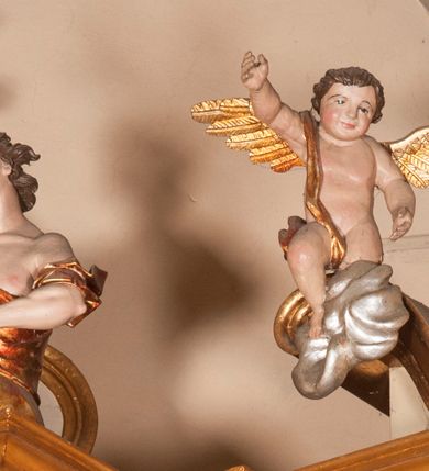 Zdjęcie nr 29: Ołtarz architektoniczny,  przyścienny, trójosiowy, jednokondygnacyjny ze zwieńczeniem. Mensa ołtarzowa kamienna, sarkofagowa, przesłonięta drewnianym antepedium, w centrum którego umieszczono pastorał, krzyż, infułę i księgę w otoczeniu winnej latorośli. Antepedium otoczone ramą ze zdobionymi narożami. Na mensie ustawiono tabernakulum dwukondygnacyjne ze zwieńczeniem, flankowane kolumnami kompozytowymi z pierścieniami w połowie. W dolnej kondygnacji metalowy front z drzwiami o wykroju łuku, zdobionymi splotem kłosów zbóż i kiści winogron. W górnej kondygnacji srebrna płaskorzeźba pelikana karmiącego trzy pisklęta. Po bokach siedzą dwa aniołki. Tabernakulum flankowane stylizowanym przestrzennym ornamentem akantowym. Nastawa posadowiona na wysokim, dekorowanym płycinami, dwudzielnym cokole, którego boczne osie zostały ustawione skośnie w stosunku do głównej. W polu centralnym obraz ze sceną wskrzeszenie Piotrowina przez św. Stanisława w kształcie prostokąta zamkniętego od góry łukiem półkolistym, w złoconej, profilowanej ramie otoczonej srebrnymi orłami oraz stylizowaną wicią roślinną. Powyżej, w zwieńczeniu gloria promienista. W jej centrum Trójca Święta: tronujący wśród obłoków i aniołków Chrystus po lewej stronie i Bóg Ojciec po prawej; powyżej nich unosi się gołębica Ducha Świętego. Otaczająca scenę gloria promienista została skomponowana z wiązek krótszych i dłuższych promieni naprzemiennie srebrnych i złotych, rzadziej rozlokowanych w dolnej części. Boczne osie składają się z ustawionych uskokowo na tle pilastrów par kolumn kompozytowych podtrzymujących rozbudowane, wyłamane na ich osiach belkowanie. Cokoły kolumn są dekorowane płycinami wypełnionymi ornamentem, a między nimi  na konsolach ustawiono figury świętych: Piotra po prawej stronie i Pawła po lewej. Na zewnętrznych częściach belkowania umieszczono woluty, na których posadowiono nagie, przewiązane jedynie złotymi szarfami aniołki wskazujące scenę w glorii. Na wewnętrznych częściach siedzi para większych, ubranych w złoto-czerwone suknie aniołów ukazanych w skręcie, spoglądających we wskazywanym kierunku. 
Ołtarz polichromowany na kolor kremowy, płyciny na ciemnożółty i brązowy, profile również na biało i brązowo; ornamenty, profile, detale oraz kolumny złocone.  
