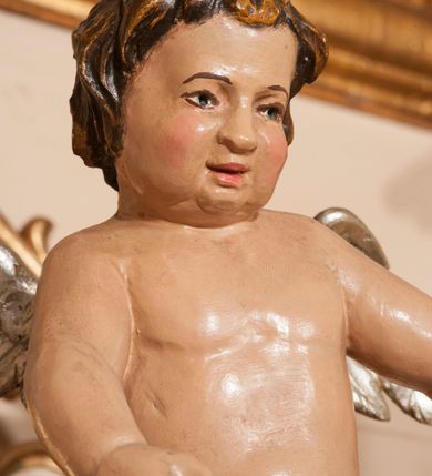 Zdjęcie nr 27: Ołtarz architektoniczny,  przyścienny, trójosiowy, jednokondygnacyjny ze zwieńczeniem. Mensa ołtarzowa kamienna, sarkofagowa, przesłonięta drewnianym antepedium, w centrum którego umieszczono pastorał, krzyż, infułę i księgę w otoczeniu winnej latorośli. Antepedium otoczone ramą ze zdobionymi narożami. Na mensie ustawiono tabernakulum dwukondygnacyjne ze zwieńczeniem, flankowane kolumnami kompozytowymi z pierścieniami w połowie. W dolnej kondygnacji metalowy front z drzwiami o wykroju łuku, zdobionymi splotem kłosów zbóż i kiści winogron. W górnej kondygnacji srebrna płaskorzeźba pelikana karmiącego trzy pisklęta. Po bokach siedzą dwa aniołki. Tabernakulum flankowane stylizowanym przestrzennym ornamentem akantowym. Nastawa posadowiona na wysokim, dekorowanym płycinami, dwudzielnym cokole, którego boczne osie zostały ustawione skośnie w stosunku do głównej. W polu centralnym obraz ze sceną wskrzeszenie Piotrowina przez św. Stanisława w kształcie prostokąta zamkniętego od góry łukiem półkolistym, w złoconej, profilowanej ramie otoczonej srebrnymi orłami oraz stylizowaną wicią roślinną. Powyżej, w zwieńczeniu gloria promienista. W jej centrum Trójca Święta: tronujący wśród obłoków i aniołków Chrystus po lewej stronie i Bóg Ojciec po prawej; powyżej nich unosi się gołębica Ducha Świętego. Otaczająca scenę gloria promienista została skomponowana z wiązek krótszych i dłuższych promieni naprzemiennie srebrnych i złotych, rzadziej rozlokowanych w dolnej części. Boczne osie składają się z ustawionych uskokowo na tle pilastrów par kolumn kompozytowych podtrzymujących rozbudowane, wyłamane na ich osiach belkowanie. Cokoły kolumn są dekorowane płycinami wypełnionymi ornamentem, a między nimi  na konsolach ustawiono figury świętych: Piotra po prawej stronie i Pawła po lewej. Na zewnętrznych częściach belkowania umieszczono woluty, na których posadowiono nagie, przewiązane jedynie złotymi szarfami aniołki wskazujące scenę w glorii. Na wewnętrznych częściach siedzi para większych, ubranych w złoto-czerwone suknie aniołów ukazanych w skręcie, spoglądających we wskazywanym kierunku. 
Ołtarz polichromowany na kolor kremowy, płyciny na ciemnożółty i brązowy, profile również na biało i brązowo; ornamenty, profile, detale oraz kolumny złocone.  
