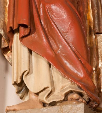 Zdjęcie nr 12: Ołtarz architektoniczny,  przyścienny, trójosiowy, jednokondygnacyjny ze zwieńczeniem. Mensa ołtarzowa kamienna, sarkofagowa, przesłonięta drewnianym antepedium, w centrum którego umieszczono pastorał, krzyż, infułę i księgę w otoczeniu winnej latorośli. Antepedium otoczone ramą ze zdobionymi narożami. Na mensie ustawiono tabernakulum dwukondygnacyjne ze zwieńczeniem, flankowane kolumnami kompozytowymi z pierścieniami w połowie. W dolnej kondygnacji metalowy front z drzwiami o wykroju łuku, zdobionymi splotem kłosów zbóż i kiści winogron. W górnej kondygnacji srebrna płaskorzeźba pelikana karmiącego trzy pisklęta. Po bokach siedzą dwa aniołki. Tabernakulum flankowane stylizowanym przestrzennym ornamentem akantowym. Nastawa posadowiona na wysokim, dekorowanym płycinami, dwudzielnym cokole, którego boczne osie zostały ustawione skośnie w stosunku do głównej. W polu centralnym obraz ze sceną wskrzeszenie Piotrowina przez św. Stanisława w kształcie prostokąta zamkniętego od góry łukiem półkolistym, w złoconej, profilowanej ramie otoczonej srebrnymi orłami oraz stylizowaną wicią roślinną. Powyżej, w zwieńczeniu gloria promienista. W jej centrum Trójca Święta: tronujący wśród obłoków i aniołków Chrystus po lewej stronie i Bóg Ojciec po prawej; powyżej nich unosi się gołębica Ducha Świętego. Otaczająca scenę gloria promienista została skomponowana z wiązek krótszych i dłuższych promieni naprzemiennie srebrnych i złotych, rzadziej rozlokowanych w dolnej części. Boczne osie składają się z ustawionych uskokowo na tle pilastrów par kolumn kompozytowych podtrzymujących rozbudowane, wyłamane na ich osiach belkowanie. Cokoły kolumn są dekorowane płycinami wypełnionymi ornamentem, a między nimi  na konsolach ustawiono figury świętych: Piotra po prawej stronie i Pawła po lewej. Na zewnętrznych częściach belkowania umieszczono woluty, na których posadowiono nagie, przewiązane jedynie złotymi szarfami aniołki wskazujące scenę w glorii. Na wewnętrznych częściach siedzi para większych, ubranych w złoto-czerwone suknie aniołów ukazanych w skręcie, spoglądających we wskazywanym kierunku. 
Ołtarz polichromowany na kolor kremowy, płyciny na ciemnożółty i brązowy, profile również na biało i brązowo; ornamenty, profile, detale oraz kolumny złocone.  
