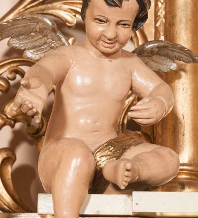 Zdjęcie nr 22: Ołtarz architektoniczny,  przyścienny, trójosiowy, jednokondygnacyjny ze zwieńczeniem. Mensa ołtarzowa kamienna, sarkofagowa, przesłonięta drewnianym antepedium, w centrum którego umieszczono pastorał, krzyż, infułę i księgę w otoczeniu winnej latorośli. Antepedium otoczone ramą ze zdobionymi narożami. Na mensie ustawiono tabernakulum dwukondygnacyjne ze zwieńczeniem, flankowane kolumnami kompozytowymi z pierścieniami w połowie. W dolnej kondygnacji metalowy front z drzwiami o wykroju łuku, zdobionymi splotem kłosów zbóż i kiści winogron. W górnej kondygnacji srebrna płaskorzeźba pelikana karmiącego trzy pisklęta. Po bokach siedzą dwa aniołki. Tabernakulum flankowane stylizowanym przestrzennym ornamentem akantowym. Nastawa posadowiona na wysokim, dekorowanym płycinami, dwudzielnym cokole, którego boczne osie zostały ustawione skośnie w stosunku do głównej. W polu centralnym obraz ze sceną wskrzeszenie Piotrowina przez św. Stanisława w kształcie prostokąta zamkniętego od góry łukiem półkolistym, w złoconej, profilowanej ramie otoczonej srebrnymi orłami oraz stylizowaną wicią roślinną. Powyżej, w zwieńczeniu gloria promienista. W jej centrum Trójca Święta: tronujący wśród obłoków i aniołków Chrystus po lewej stronie i Bóg Ojciec po prawej; powyżej nich unosi się gołębica Ducha Świętego. Otaczająca scenę gloria promienista została skomponowana z wiązek krótszych i dłuższych promieni naprzemiennie srebrnych i złotych, rzadziej rozlokowanych w dolnej części. Boczne osie składają się z ustawionych uskokowo na tle pilastrów par kolumn kompozytowych podtrzymujących rozbudowane, wyłamane na ich osiach belkowanie. Cokoły kolumn są dekorowane płycinami wypełnionymi ornamentem, a między nimi  na konsolach ustawiono figury świętych: Piotra po prawej stronie i Pawła po lewej. Na zewnętrznych częściach belkowania umieszczono woluty, na których posadowiono nagie, przewiązane jedynie złotymi szarfami aniołki wskazujące scenę w glorii. Na wewnętrznych częściach siedzi para większych, ubranych w złoto-czerwone suknie aniołów ukazanych w skręcie, spoglądających we wskazywanym kierunku. 
Ołtarz polichromowany na kolor kremowy, płyciny na ciemnożółty i brązowy, profile również na biało i brązowo; ornamenty, profile, detale oraz kolumny złocone.  
