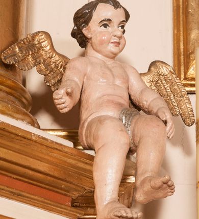 Zdjęcie nr 24: Ołtarz architektoniczny,  przyścienny, trójosiowy, jednokondygnacyjny ze zwieńczeniem. Mensa ołtarzowa kamienna, sarkofagowa, przesłonięta drewnianym antepedium, w centrum którego umieszczono pastorał, krzyż, infułę i księgę w otoczeniu winnej latorośli. Antepedium otoczone ramą ze zdobionymi narożami. Na mensie ustawiono tabernakulum dwukondygnacyjne ze zwieńczeniem, flankowane kolumnami kompozytowymi z pierścieniami w połowie. W dolnej kondygnacji metalowy front z drzwiami o wykroju łuku, zdobionymi splotem kłosów zbóż i kiści winogron. W górnej kondygnacji srebrna płaskorzeźba pelikana karmiącego trzy pisklęta. Po bokach siedzą dwa aniołki. Tabernakulum flankowane stylizowanym przestrzennym ornamentem akantowym. Nastawa posadowiona na wysokim, dekorowanym płycinami, dwudzielnym cokole, którego boczne osie zostały ustawione skośnie w stosunku do głównej. W polu centralnym obraz ze sceną wskrzeszenie Piotrowina przez św. Stanisława w kształcie prostokąta zamkniętego od góry łukiem półkolistym, w złoconej, profilowanej ramie otoczonej srebrnymi orłami oraz stylizowaną wicią roślinną. Powyżej, w zwieńczeniu gloria promienista. W jej centrum Trójca Święta: tronujący wśród obłoków i aniołków Chrystus po lewej stronie i Bóg Ojciec po prawej; powyżej nich unosi się gołębica Ducha Świętego. Otaczająca scenę gloria promienista została skomponowana z wiązek krótszych i dłuższych promieni naprzemiennie srebrnych i złotych, rzadziej rozlokowanych w dolnej części. Boczne osie składają się z ustawionych uskokowo na tle pilastrów par kolumn kompozytowych podtrzymujących rozbudowane, wyłamane na ich osiach belkowanie. Cokoły kolumn są dekorowane płycinami wypełnionymi ornamentem, a między nimi  na konsolach ustawiono figury świętych: Piotra po prawej stronie i Pawła po lewej. Na zewnętrznych częściach belkowania umieszczono woluty, na których posadowiono nagie, przewiązane jedynie złotymi szarfami aniołki wskazujące scenę w glorii. Na wewnętrznych częściach siedzi para większych, ubranych w złoto-czerwone suknie aniołów ukazanych w skręcie, spoglądających we wskazywanym kierunku. 
Ołtarz polichromowany na kolor kremowy, płyciny na ciemnożółty i brązowy, profile również na biało i brązowo; ornamenty, profile, detale oraz kolumny złocone.  
