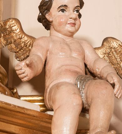 Zdjęcie nr 25: Ołtarz architektoniczny,  przyścienny, trójosiowy, jednokondygnacyjny ze zwieńczeniem. Mensa ołtarzowa kamienna, sarkofagowa, przesłonięta drewnianym antepedium, w centrum którego umieszczono pastorał, krzyż, infułę i księgę w otoczeniu winnej latorośli. Antepedium otoczone ramą ze zdobionymi narożami. Na mensie ustawiono tabernakulum dwukondygnacyjne ze zwieńczeniem, flankowane kolumnami kompozytowymi z pierścieniami w połowie. W dolnej kondygnacji metalowy front z drzwiami o wykroju łuku, zdobionymi splotem kłosów zbóż i kiści winogron. W górnej kondygnacji srebrna płaskorzeźba pelikana karmiącego trzy pisklęta. Po bokach siedzą dwa aniołki. Tabernakulum flankowane stylizowanym przestrzennym ornamentem akantowym. Nastawa posadowiona na wysokim, dekorowanym płycinami, dwudzielnym cokole, którego boczne osie zostały ustawione skośnie w stosunku do głównej. W polu centralnym obraz ze sceną wskrzeszenie Piotrowina przez św. Stanisława w kształcie prostokąta zamkniętego od góry łukiem półkolistym, w złoconej, profilowanej ramie otoczonej srebrnymi orłami oraz stylizowaną wicią roślinną. Powyżej, w zwieńczeniu gloria promienista. W jej centrum Trójca Święta: tronujący wśród obłoków i aniołków Chrystus po lewej stronie i Bóg Ojciec po prawej; powyżej nich unosi się gołębica Ducha Świętego. Otaczająca scenę gloria promienista została skomponowana z wiązek krótszych i dłuższych promieni naprzemiennie srebrnych i złotych, rzadziej rozlokowanych w dolnej części. Boczne osie składają się z ustawionych uskokowo na tle pilastrów par kolumn kompozytowych podtrzymujących rozbudowane, wyłamane na ich osiach belkowanie. Cokoły kolumn są dekorowane płycinami wypełnionymi ornamentem, a między nimi  na konsolach ustawiono figury świętych: Piotra po prawej stronie i Pawła po lewej. Na zewnętrznych częściach belkowania umieszczono woluty, na których posadowiono nagie, przewiązane jedynie złotymi szarfami aniołki wskazujące scenę w glorii. Na wewnętrznych częściach siedzi para większych, ubranych w złoto-czerwone suknie aniołów ukazanych w skręcie, spoglądających we wskazywanym kierunku. 
Ołtarz polichromowany na kolor kremowy, płyciny na ciemnożółty i brązowy, profile również na biało i brązowo; ornamenty, profile, detale oraz kolumny złocone.  
