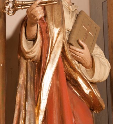 Zdjęcie nr 8: Ołtarz architektoniczny,  przyścienny, trójosiowy, jednokondygnacyjny ze zwieńczeniem. Mensa ołtarzowa kamienna, sarkofagowa, przesłonięta drewnianym antepedium, w centrum którego umieszczono pastorał, krzyż, infułę i księgę w otoczeniu winnej latorośli. Antepedium otoczone ramą ze zdobionymi narożami. Na mensie ustawiono tabernakulum dwukondygnacyjne ze zwieńczeniem, flankowane kolumnami kompozytowymi z pierścieniami w połowie. W dolnej kondygnacji metalowy front z drzwiami o wykroju łuku, zdobionymi splotem kłosów zbóż i kiści winogron. W górnej kondygnacji srebrna płaskorzeźba pelikana karmiącego trzy pisklęta. Po bokach siedzą dwa aniołki. Tabernakulum flankowane stylizowanym przestrzennym ornamentem akantowym. Nastawa posadowiona na wysokim, dekorowanym płycinami, dwudzielnym cokole, którego boczne osie zostały ustawione skośnie w stosunku do głównej. W polu centralnym obraz ze sceną wskrzeszenie Piotrowina przez św. Stanisława w kształcie prostokąta zamkniętego od góry łukiem półkolistym, w złoconej, profilowanej ramie otoczonej srebrnymi orłami oraz stylizowaną wicią roślinną. Powyżej, w zwieńczeniu gloria promienista. W jej centrum Trójca Święta: tronujący wśród obłoków i aniołków Chrystus po lewej stronie i Bóg Ojciec po prawej; powyżej nich unosi się gołębica Ducha Świętego. Otaczająca scenę gloria promienista została skomponowana z wiązek krótszych i dłuższych promieni naprzemiennie srebrnych i złotych, rzadziej rozlokowanych w dolnej części. Boczne osie składają się z ustawionych uskokowo na tle pilastrów par kolumn kompozytowych podtrzymujących rozbudowane, wyłamane na ich osiach belkowanie. Cokoły kolumn są dekorowane płycinami wypełnionymi ornamentem, a między nimi  na konsolach ustawiono figury świętych: Piotra po prawej stronie i Pawła po lewej. Na zewnętrznych częściach belkowania umieszczono woluty, na których posadowiono nagie, przewiązane jedynie złotymi szarfami aniołki wskazujące scenę w glorii. Na wewnętrznych częściach siedzi para większych, ubranych w złoto-czerwone suknie aniołów ukazanych w skręcie, spoglądających we wskazywanym kierunku. 
Ołtarz polichromowany na kolor kremowy, płyciny na ciemnożółty i brązowy, profile również na biało i brązowo; ornamenty, profile, detale oraz kolumny złocone.  
