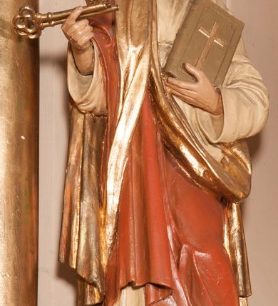 Zdjęcie nr 9: Ołtarz architektoniczny,  przyścienny, trójosiowy, jednokondygnacyjny ze zwieńczeniem. Mensa ołtarzowa kamienna, sarkofagowa, przesłonięta drewnianym antepedium, w centrum którego umieszczono pastorał, krzyż, infułę i księgę w otoczeniu winnej latorośli. Antepedium otoczone ramą ze zdobionymi narożami. Na mensie ustawiono tabernakulum dwukondygnacyjne ze zwieńczeniem, flankowane kolumnami kompozytowymi z pierścieniami w połowie. W dolnej kondygnacji metalowy front z drzwiami o wykroju łuku, zdobionymi splotem kłosów zbóż i kiści winogron. W górnej kondygnacji srebrna płaskorzeźba pelikana karmiącego trzy pisklęta. Po bokach siedzą dwa aniołki. Tabernakulum flankowane stylizowanym przestrzennym ornamentem akantowym. Nastawa posadowiona na wysokim, dekorowanym płycinami, dwudzielnym cokole, którego boczne osie zostały ustawione skośnie w stosunku do głównej. W polu centralnym obraz ze sceną wskrzeszenie Piotrowina przez św. Stanisława w kształcie prostokąta zamkniętego od góry łukiem półkolistym, w złoconej, profilowanej ramie otoczonej srebrnymi orłami oraz stylizowaną wicią roślinną. Powyżej, w zwieńczeniu gloria promienista. W jej centrum Trójca Święta: tronujący wśród obłoków i aniołków Chrystus po lewej stronie i Bóg Ojciec po prawej; powyżej nich unosi się gołębica Ducha Świętego. Otaczająca scenę gloria promienista została skomponowana z wiązek krótszych i dłuższych promieni naprzemiennie srebrnych i złotych, rzadziej rozlokowanych w dolnej części. Boczne osie składają się z ustawionych uskokowo na tle pilastrów par kolumn kompozytowych podtrzymujących rozbudowane, wyłamane na ich osiach belkowanie. Cokoły kolumn są dekorowane płycinami wypełnionymi ornamentem, a między nimi  na konsolach ustawiono figury świętych: Piotra po prawej stronie i Pawła po lewej. Na zewnętrznych częściach belkowania umieszczono woluty, na których posadowiono nagie, przewiązane jedynie złotymi szarfami aniołki wskazujące scenę w glorii. Na wewnętrznych częściach siedzi para większych, ubranych w złoto-czerwone suknie aniołów ukazanych w skręcie, spoglądających we wskazywanym kierunku. 
Ołtarz polichromowany na kolor kremowy, płyciny na ciemnożółty i brązowy, profile również na biało i brązowo; ornamenty, profile, detale oraz kolumny złocone.  
