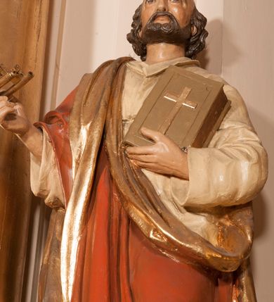 Zdjęcie nr 2: Rzeźba drążona na cokole przedstawiająca św. Piotra ukazanego w całej postaci, zwróconego nieznacznie w lewo. Święty prawą, zgiętą w łokciu ręką trzyma dwa złożone razem klucze, lewą podtrzymuje zamkniętą księgę z krzyżem na okładce. Ma owalną, szczupłą twarz z dużymi, szeroko otwartymi oczami, prostym nosem oraz wydatnymi  zakolami; okalają ją ciemnobrązowe, krótkie, zaczesane do tyłu włosy. Święty ma krótką brodę oraz wąsy. Jest ubrany w kremową suknię z kołnierzykiem i długimi rękawami oraz czerwony płaszcz ze złotym podbiciem przerzucony przez prawe ramię, owijający się wokół lewego biodra. Tkanina płaszcza spływa do ziemi podłużnymi, równoległymi fałdami. 
W partiach ciała polichromia naturalistyczna, płaszcz i atrybuty złocone. 
