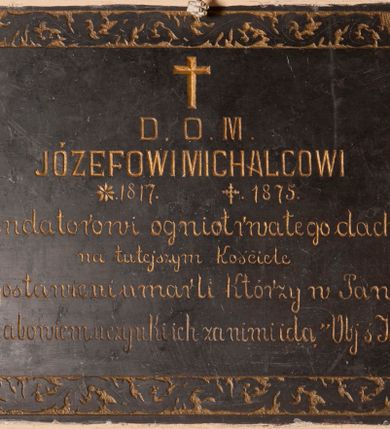 Zdjęcie nr 1: Tablica epitafijna w formie leżącego prostokąta wmurowana w ścianę kościoła. Na środku umieszczono złoconą inskrypcję „D(EO) O(PTIMO) M(AXIMO) / JÓZEFOWI MICHALCOWI / *1817 +1875 / Fundatorowi ogniotrwałego dachu / na tutejszym kościele / Błogosławieni umarli Którzy w Panu / umierają abowiem uczynki ich za nimi idą „Obj(awienie) ś[więtego] Jana XIV 13”. Treść ujęto bordiurą z faliście wijącej się wici roślinnej.   