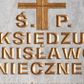 Zdjęcie nr 1: Tablica epitafijna w formie leżącego prostokąta wmurowana w ścianę kościoła. W narożnikach widoczne śruby mocujące, na środku umieszczono złoconą inskrypcję „Ś(WIĘTEJ) P(AMIĘCI) / KSIĘDZU / STANISŁAWOWI / KONIECZNEMU / PROBOSZCZOWI W ŚWIĄTNIKACH GÓRNYCH / W LATACH 1982-1994 / ODNOWICIELOWI TEJ ŚWIĄTYNI I SERC NASZYCH / WDZIĘCZNI PARAFIANIE”. 