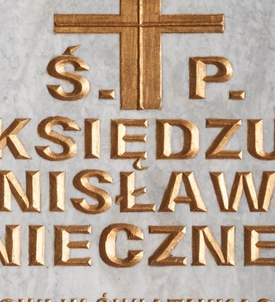 Zdjęcie nr 1: Tablica epitafijna w formie leżącego prostokąta wmurowana w ścianę kościoła. W narożnikach widoczne śruby mocujące, na środku umieszczono złoconą inskrypcję „Ś(WIĘTEJ) P(AMIĘCI) / KSIĘDZU / STANISŁAWOWI / KONIECZNEMU / PROBOSZCZOWI W ŚWIĄTNIKACH GÓRNYCH / W LATACH 1982-1994 / ODNOWICIELOWI TEJ ŚWIĄTYNI I SERC NASZYCH / WDZIĘCZNI PARAFIANIE”. 