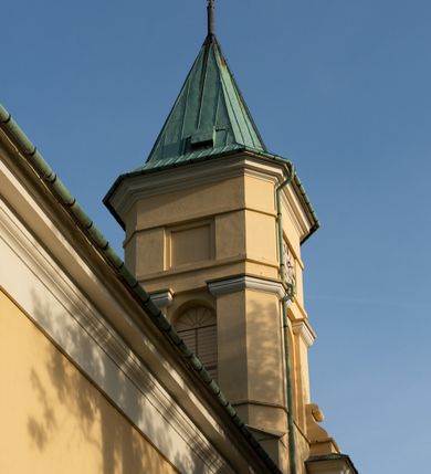 Zdjęcie nr 21: Kościół murowany, trójnawowy, halowy, na rzucie prostokąta z wydłużonym, skierowanym na północ prezbiterium z dobudowaną po zachodniej stronie zakrystią. Prezbiterium jednoprzęsłowe, węższe od korpusu, zamknięte prosto. Nawa główna oraz boczne dwuprzęsłowe, rozdzielone masywnymi opilastrowanymi filarami; artykulacja ścian przy pomocy filarów. Sklepienie prezbiterium kolebkowe, naw żagielkowe, przedzielone gurtami. Od południa chór muzyczny mieszczący się między pierwszymi filarami i powyżej kruchty wejściowej. W prezbiterium jedno okno od wschodu, drugie w zakrystii, w nawach bocznych po dwa. Główne wejście od południa flankowane przez dwa boczne, kolejne do zakrystii i między zakrystią i prezbiterium. Niektóre okna wypełnione gomułkami, ściany i sklepienia kościoła pokrywa polichromia utworzona z dekoracji floralnych i umieszczonych w jej obrębie symboli ewangelistów, herbów i putt wykonujących prace kojarzące się z regionem (bartnicze, ślusarskie, kowalskie itd.). Fasada dwuwieżowa, trójosiowa, dwuprzęsłowa, z portalem na każdej osi. Podziały pionowe przeprowadzono za pomocą półkolumienek i lizen, poziome w formie fryzu kostkowego wyniesionego nad środkowym portalem. Drzwi osi głównej w kształcie stojącego prostokąta ujętego półkolumnami dźwigającymi archiwoltę utworzoną z trzech łuków i trójkątny przyczółek. Drzwi osi bocznych zwieńczone przyczółkami. W drugiej kondygnacji na osi okulus i półokrągła konchowa wnęka z figurą Najświętszego Serca Jezusa poniżej trójkątnego szczytu dekorowanego fryzem arkadkowym. W osiach bocznych okna w kształcie stojącego prostokąta zamkniętego półkoliście. Wyżej dwie kondygnacje wież oddzielone gzymsem, w pierwszej  umieszczono okna, w drugiej tarcze zegarów. Elewacje boczne gładkie, przeprute jedynie oknami. Nawy przykrywa dach dwuspadowy, wieże namiotowe z fartuchem zwieńczone krzyżami.