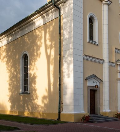 Zdjęcie nr 34: Kościół murowany, trójnawowy, halowy, na rzucie prostokąta z wydłużonym, skierowanym na północ prezbiterium z dobudowaną po zachodniej stronie zakrystią. Prezbiterium jednoprzęsłowe, węższe od korpusu, zamknięte prosto. Nawa główna oraz boczne dwuprzęsłowe, rozdzielone masywnymi opilastrowanymi filarami; artykulacja ścian przy pomocy filarów. Sklepienie prezbiterium kolebkowe, naw żagielkowe, przedzielone gurtami. Od południa chór muzyczny mieszczący się między pierwszymi filarami i powyżej kruchty wejściowej. W prezbiterium jedno okno od wschodu, drugie w zakrystii, w nawach bocznych po dwa. Główne wejście od południa flankowane przez dwa boczne, kolejne do zakrystii i między zakrystią i prezbiterium. Niektóre okna wypełnione gomułkami, ściany i sklepienia kościoła pokrywa polichromia utworzona z dekoracji floralnych i umieszczonych w jej obrębie symboli ewangelistów, herbów i putt wykonujących prace kojarzące się z regionem (bartnicze, ślusarskie, kowalskie itd.). Fasada dwuwieżowa, trójosiowa, dwuprzęsłowa, z portalem na każdej osi. Podziały pionowe przeprowadzono za pomocą półkolumienek i lizen, poziome w formie fryzu kostkowego wyniesionego nad środkowym portalem. Drzwi osi głównej w kształcie stojącego prostokąta ujętego półkolumnami dźwigającymi archiwoltę utworzoną z trzech łuków i trójkątny przyczółek. Drzwi osi bocznych zwieńczone przyczółkami. W drugiej kondygnacji na osi okulus i półokrągła konchowa wnęka z figurą Najświętszego Serca Jezusa poniżej trójkątnego szczytu dekorowanego fryzem arkadkowym. W osiach bocznych okna w kształcie stojącego prostokąta zamkniętego półkoliście. Wyżej dwie kondygnacje wież oddzielone gzymsem, w pierwszej  umieszczono okna, w drugiej tarcze zegarów. Elewacje boczne gładkie, przeprute jedynie oknami. Nawy przykrywa dach dwuspadowy, wieże namiotowe z fartuchem zwieńczone krzyżami.
