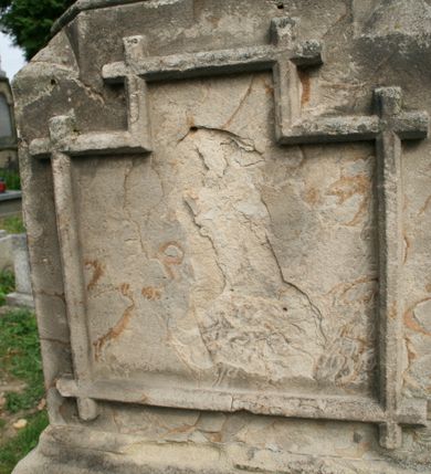 Zdjęcie nr 3: Nagrobek wolnostojący złożony z dwustrefowego cokołu podtrzymującego dwustrefowy korpus zwieńczony krzyżem łacińskim. Cokół jest gładki, dolna część niższa i szersza od górnej. Dolna część korpusu jest prostopadłościenna, na frontowej ścianie, wmurowano w ramę w kształcie leżącego prostokąta z uskokiem marmurową płytę z inskrypcją „D(eo) O(ptimo) M(aximo) / Ś(więtej) P(amięci) / TU SPOCZYWA / Kś. JAK SŁOMKA / PARAFIANIN / ZMARŁ w 36 ROKU ŻYCIA / PO 9 LATACH KAPŁAŃSTWA / w 1874 r(oku) / POKÓJ JEGO DUSZY / ODN(OWILI) PARAFIANIE 1981” poniżej rytego w piaskowcu „D(eo) O(ptimo) M(aximo)”. Na tylnej ścianie, w takiej samej ramie znajduje się nieczytelny napis zaczynający się od „D(eo) O(ptimo) M(aximo)”. Górna część korpusu jest  wieloboczna, smuklejsza i wyższa niż dolna, zakończona gzymsem. Każdą jej ściankę dekoruje ostrołukowa blenda. Całość wieńczy krzyż łaciński o ramionach stylizowanych na utworzone z gałęzi. 

