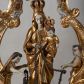 Zdjęcie nr 1: Na profilowanym, prostopadłościennym postumencie ustawiona pełnoplastyczna figura Matki Boskiej z Dzieciątkiem stojącej na niebieskim globie ziemskim, depczącej węża z czerwonym jabłkiem w pysku i podtrzymującej  różaniec. Maria jest ubrana w długie, złocone szaty, na lewym ręku podtrzymuje analogicznie ubrane Dzieciątko. Obie postaci w koronach zamkniętych. Po bokach i na górze pełnoplastyczne wizerunki aniołków siedzących na obłokach i podtrzymujących części różańca oraz różany wieniec nad głową Marii. Całość otoczona ażurową strukturą utworzoną z esowato akantowo-rocaille'owych wygiętych wolut, na których ustawiony jest bogato dekorowany lambrekinem baldachim. W zwieńczeniu gloria promienista z monogramem maryjnym w obłokach. Odsłonięte partie ciała postaci polichromowane naturalistycznie, pozostałe fragmenty srebrzone i złocone; postument w kolorze jasnozielonym ze złoconymi profilami.