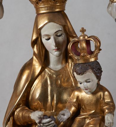 Zdjęcie nr 3: Na profilowanym, prostopadłościennym postumencie ustawiona pełnoplastyczna figura Matki Boskiej z Dzieciątkiem stojącej na niebieskim globie ziemskim, depczącej węża z czerwonym jabłkiem w pysku i podtrzymującej  różaniec. Maria jest ubrana w długie, złocone szaty, na lewym ręku podtrzymuje analogicznie ubrane Dzieciątko. Obie postaci w koronach zamkniętych. Po bokach i na górze pełnoplastyczne wizerunki aniołków siedzących na obłokach i podtrzymujących części różańca oraz różany wieniec nad głową Marii. Całość otoczona ażurową strukturą utworzoną z esowato akantowo-rocaille'owych wygiętych wolut, na których ustawiony jest bogato dekorowany lambrekinem baldachim. W zwieńczeniu gloria promienista z monogramem maryjnym w obłokach. Odsłonięte partie ciała postaci polichromowane naturalistycznie, pozostałe fragmenty srebrzone i złocone; postument w kolorze jasnozielonym ze złoconymi profilami.