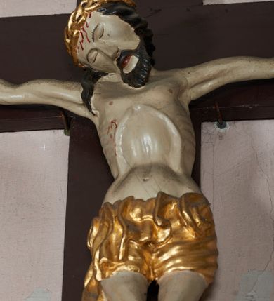 Zdjęcie nr 3: W centrum postać zmarłego Chrystusa, przybitego trzema gwoździami do krzyża. Postać w delikatnym zwisie, o szeroko rozłożonych ramionach i delikatnie przegiętej sylwetce. Duża głowa w koronie cierniowej opada na prawe ramię; twarz o sumarycznych rysach, okolona zarostem; włosy w postaci pukli opadają na ramię. Ciało naprężone, wychudzone, ekspresyjnie kształtowane, uwypuklone poszczególne elementy anatomiczne, z zaznaczonymi śladami męki. Perizonium w formie tkaniny ściśle opasującej biodra, drapowanej w spływające faliście fałdy, ze zwisem na prawym boku. Titulus w formie banderoli z napisem „INRI”.Po lewej stronie figura św. Elżbiety, zwróconej frontalnie z wyciągniętymi przed siebie rękami. Twarz pełna, niezindywidualizowana. Na nakrytej welonem głowie ma koronę. Postać ubrana w błękitną tunikę przepasaną w talii złotą szarfą i podwikę; na ramiona ma narzucony czerwony płaszcz. Po prawej postać św. Katarzyny Sieneńskiej w analogicznym układzie ciała. Twarz pełna, również niezindywidualizowana. Święta jest ubrana w habit dominikański. Karnacja postaci bardzo jasna. 