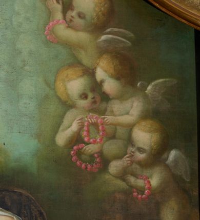 Zdjęcie nr 14: Obraz w formie stojącego prostokąta zamkniętego łukiem nadwieszonym z uskokiem. W centrum tronuje Maria z Dzieciątkiem na kolanach i półksiężycem pod prawą stopą. Postać jest ustawiona frontalnie, delikatnie pochyla głowę w prawo. Prawą ręką wysuniętą w przód podaje różaniec św. Dominikowi, lewą obejmuje Dzieciątko. Maria ma twarz o młodzieńczych, delikatnych rysach, z wyraźnie zarysowanym długim nosem, półprzymkniętymi powiekami. Jasne włosy z przedziałkiem pośrodku, opadają  zwinięte w pukle na ramiona i plecy. Maria jest ubrana w czerwoną tunikę przepasaną w talii oraz niebieski płaszcz spięty na piersi zaponą, przerzucony z przodu przez kolana. Dzieciątko zwrócone w trzech czwartych w prawo, z korpusem skierowanym w lewo; delikatnie pochylone; obiema dłońmi trzyma wieniec z kwiatów nad głową św. Katarzyny. Ma okrągłą twarz o wyraźnych rysach, wysokie czoło, okrągłe oczy, małe usta i nos; włosy krótkie, jasne, układające się w loki. Jest ubrane w białą tunikę w podwiniętymi rękawami. Po lewej stronie, klęcząca postać św. Dominika, ukazanego w całej postaci, z prawego profilu. Święty prawą rękę składa na piersi, lewą odbiera różaniec od Marii. Głowę ma uniesioną lekko ku górze, twarz szczupłą, o ostrym profilu nosa, wzrok kieruje na Marię; włosy krótkie z tonsurą, krótka broda. Święty ubrany jest w habit dominikański. U jego stóp brązowy pies z pochodnią w pysku. Po prawej stronie obrazu postać klęczącej św. Katarzyny Sieneńskiej ukazanej w całej postaci, zwróconej w prawo, z lewą ręką opuszczoną, prawą zaś złożoną na piersi. Twarz świętej jest owalna, o dziewczęcych rysach i jasnej karnacji, wzrok skierowany ku górze w stronę Marii, nos długi o prostym profilu, usta niewielkie. U góry kompozycji, po bokach Marii uskrzydlone, nagie putta trzymające różane wianki. Tło szaro-zielonkawe wypełnione powtarzającym się motywem główek anielskich.