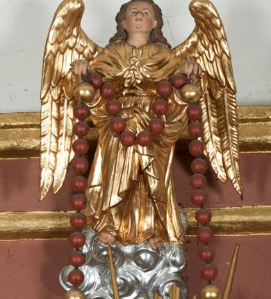 Zdjęcie nr 6: Ołtarz przyścienny, architektoniczny, jednoosiowy, jednokondygnacyjny ze zwieńczeniem i uszakami. Mensa kamienna ustawiona na dwóch niskich kolumnach o impostowych kapitelach. Nastawa drewniana, ujęta korynckimi kolumnami ustawionymi ukośnie na wysokich postumentach. Dźwigają one pełne, wyłamane na ich osiach belkowanie. Fryz jest dekorowany akantem, jajownikiem oraz kostkowaniem; gzyms silnie wystający, profilowany. Na osi kolumn ustawione pełnoplastyczne figury klęczących aniołów w złoconych szatach. W kondygnacji obraz Matki Boskiej Różańcowej w kształcie stojącego prostokąta zamkniętego półkoliście, otoczony wieńcami laurowymi z przetkniętymi liśćmi palmy oraz różami. Po bokach kolumn ustawione pełnoplastyczne, polichromowane i złocone figury św. Jacka (z lewej) trzymającego monstrancję i figurę Matki Boskiej tzw. Jackowej oraz św. Dominika (z prawej) trzymającego krucyfiks i księgę. Kondygnacja ujęta jest ażurowymi akantowymi uszami. W zwieńczeniu gloria promienista powyżej srebrzonych obłoków. Nad nią pełnoplastyczna figura anioła stojącego na chmurze i podtrzymującego różaniec. Struktura ołtarza w kolorze jasnozielonym, wypełnienia płycin, trzony kolumn oraz elementy gzymsu jasnoczerwone, marmoryzowane; ornamenty złocone.