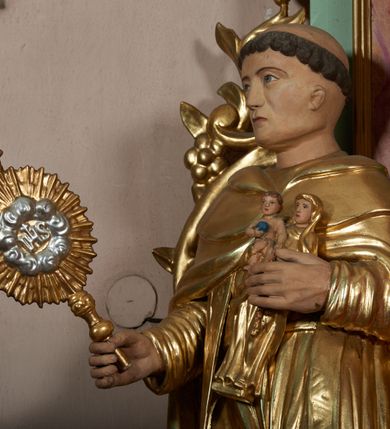 Zdjęcie nr 15: Ołtarz przyścienny, architektoniczny, jednoosiowy, jednokondygnacyjny ze zwieńczeniem i uszakami. Mensa kamienna ustawiona na dwóch niskich kolumnach o impostowych kapitelach. Nastawa drewniana, ujęta korynckimi kolumnami ustawionymi ukośnie na wysokich postumentach. Dźwigają one pełne, wyłamane na ich osiach belkowanie. Fryz jest dekorowany akantem, jajownikiem oraz kostkowaniem; gzyms silnie wystający, profilowany. Na osi kolumn ustawione pełnoplastyczne figury klęczących aniołów w złoconych szatach. W kondygnacji obraz Matki Boskiej Różańcowej w kształcie stojącego prostokąta zamkniętego półkoliście, otoczony wieńcami laurowymi z przetkniętymi liśćmi palmy oraz różami. Po bokach kolumn ustawione pełnoplastyczne, polichromowane i złocone figury św. Jacka (z lewej) trzymającego monstrancję i figurę Matki Boskiej tzw. Jackowej oraz św. Dominika (z prawej) trzymającego krucyfiks i księgę. Kondygnacja ujęta jest ażurowymi akantowymi uszami. W zwieńczeniu gloria promienista powyżej srebrzonych obłoków. Nad nią pełnoplastyczna figura anioła stojącego na chmurze i podtrzymującego różaniec. Struktura ołtarza w kolorze jasnozielonym, wypełnienia płycin, trzony kolumn oraz elementy gzymsu jasnoczerwone, marmoryzowane; ornamenty złocone.