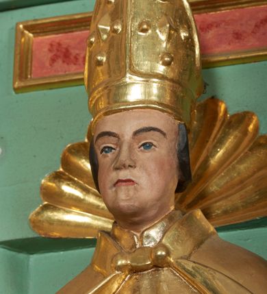 Zdjęcie nr 6: Ołtarz przyścienny, architektoniczny, trójosiowy, jednokondygnacyjny ze zwieńczeniem i uszakami. Mensa w typie sarkofagowym na niewielkim prostopadłościennym postumencie. Tabernakulum drewniane, architektoniczne, ujęte złoconymi kolumienkami dźwigającymi wyłamane i wyniesione belkowanie. Na drzwiczkach płaskorzeźbione przedstawienie kielicha z hostią. Nastawa drewniana ujęta korynckimi kolumnami ustawionymi na wysokich postumentach. Dźwigają one pełne, wyłamane na osiach kolumn i półkoliście wyniesione na osi środkowej ołtarza belkowanie. Fryz dekorowany rozetami oraz uskrzydloną główką anielską. Powyżej odcinki przyczółka, na których ustawione pełnoplastyczne figury świętych wojowników. W polu środkowym nisza zamknięta łukiem półkolistym nadwieszonym mieszcząca obraz Matki Boskiej Nieustającej Pomocy. W osiach bocznych ustawione na tle płycin pełnoplastyczne figury świętych biskupów w złoconych szatach oraz akantowe, ażurowe uszaki utworzone z wici akantowej. W zwieńczeniu obraz „Nawiedzenie Najświętszej Marii Panny” w kształcie stojącego prostokąta ujęty ażurowymi uszami utworzonymi z ornamentu mażowinowo-chrząstkowego, i winorośli. Powyżej, analogicznie, mniejszy obraz „Trójca Święta” w kształcie prostokąta stojącego o ściętych górnych narożach, zwieńczonego krzyżem równoramiennym. Struktura ołtarza w kolorze jasnozielonym, wypełnienia płycin, trzony kolumn oraz elementy gzymsu jasnoczerwone, marmoryzowane; ornamenty złocone.