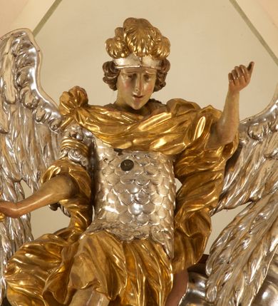 Zdjęcie nr 9: Ołtarz architektoniczny, jednokondygnacyjny, jednoosiowy, ze zwieńczeniem. Nastawa zbudowana na kamiennym, wysokim cokole, lekko wklęsła, ujęta zwielokrotnionymi pilastrami kompozytowymi o kanelowanych trzonach i zewnętrznymi, nieznacznie cofniętymi kolumnami, podtrzymującymi wyłamujące się nad nimi belkowanie. Po bokach karbowane taśmy z motywem liści akantu. W centrum obraz &quot;Przemienienie Pańskie&quot;. Nad pilastrami klęczące na obłokach uskrzydlone, adorujące anioły. Zwieńczenie o łukowato wygiętej podstawie i wklęsłych nieznacznie bokach, zwieńczone wyłamanym ku górze gzymsem zakończonym po bokach wolutami. W zwieńczenie wkomponowana okazała gloria promienista, z figurą Boga Ojca siedzącego w chmurach, Gołębicą Ducha Świętego i ukazaną na tle gzymsu postacią Archanioła Michała, ukazanego w zbroi, płaszczu na ramionach i w hełmie na głowie z mieczem w prawej dłoni. Na belkowaniu okazały kartusz ujęty puklowaną wstęgą i zwieńczony muszlą, z malowanym na srebrnym tle napisem: &quot;CHRISTO / TRANSFIGURATO / Hic est Filius meus dilectus / in quo mihi bene complacui / ipsum audite. / Matth: c. 77&quot;. Na ścianach prezbiterium, przed ołtarzem, na konsolach dwie figury św. Andrzej i św. Mateusz (?). Nastawa w całości złocona, partiami srebrzona (chmury, skrzydła aniołów, rama zwieńczenia, wstęga regencyjna po bokach), partie cokołu i fryzu z imitacją marmoryzacji.   

