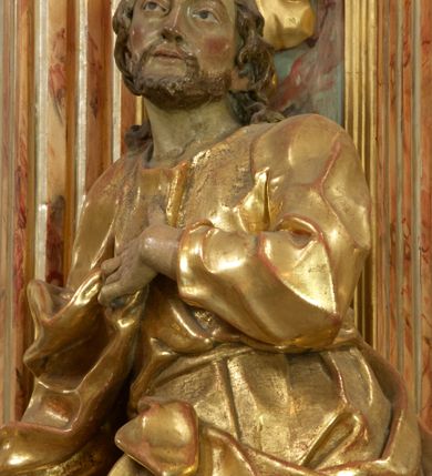 Zdjęcie nr 5: Retabulum architektoniczne, jednoosiowe, jednokondygnacyjne, ze zwieńczeniem,  posadowione na wysokim cokole. Nastawa ujęta ukośnie ustawionymi połówkami filarów na tle pilastrów, o kapitelach kompozytowych, podtrzymujących wydatne, przełamujące się nad nimi belkowanie z impostami i zwróconymi ku przodowi naczółkami, na których uskrzydlone, nagie putta, przepasane tkaninami. Zwieńczenie o lekko wklęsłych bokach zakończone gzymsem w formie łuku nadwieszonego. W partii fryzu kartusz ujęty wolutami, z lambrekinem u dołu, z muszlą palmetową u góry. W zwieńczeniu Oko Opatrzności na tle obłoków i promienistej glorii oraz dwie uskrzydlone główki anielskie. Dekorację ornamentalną tworzą kratki regencyjne, kampanule i muszle palmetowe. W części środkowej, we wnęce prostokątnej zamkniętej łukiem nadwieszonym półkolistym, w profilowanym obramieniu obraz Św. Katarzyna w profilowanej, prostokątnej ramie, nad nią rozłożysta palmeta. Wnęka ujęta kampanulami i gałązkami palmowymi. Po bokach nastawy dwie niezidentyfikowane postacie mężczyzn, całopostaciowe, w długich, silnie drapowanych sukniach, o wyrazistych twarzach, z krótkim zarostem i lekko falującymi włosami. Polichromia imitująca marmoryzację w odcieniach jasnych brązów, czerwieni i zieleni, figury o naturalnych karnacjach, złocenia szat figur i ornamentów, srebrzenia drobnych detali ornamentalnych.      
     

